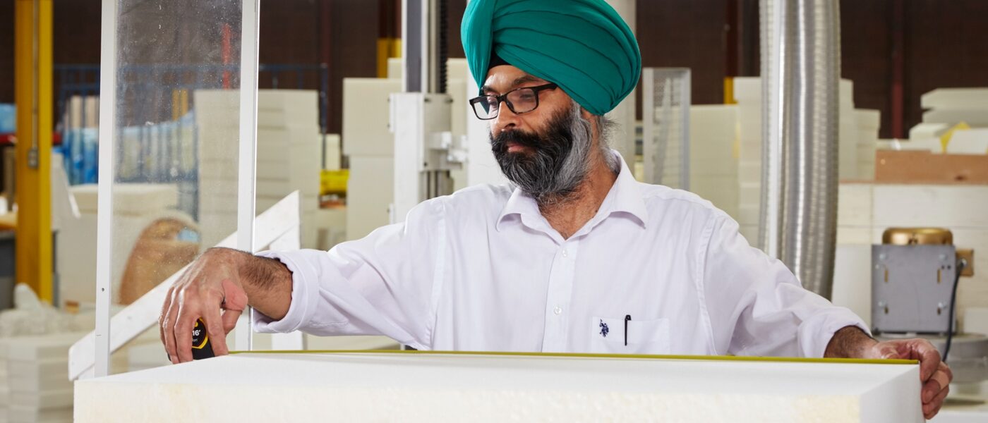 Fabricator measuring foam material on the shop floor